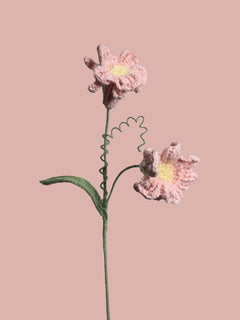 Handmade crochet daffodil flower in pink yarn, perfect for eco-friendly home decor and gifting
